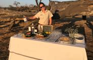 Woman in front of drinks table at sundowners in Zimbabwe 