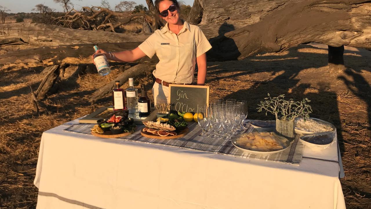 Woman in front of drinks table at sundowners in Zimbabwe 