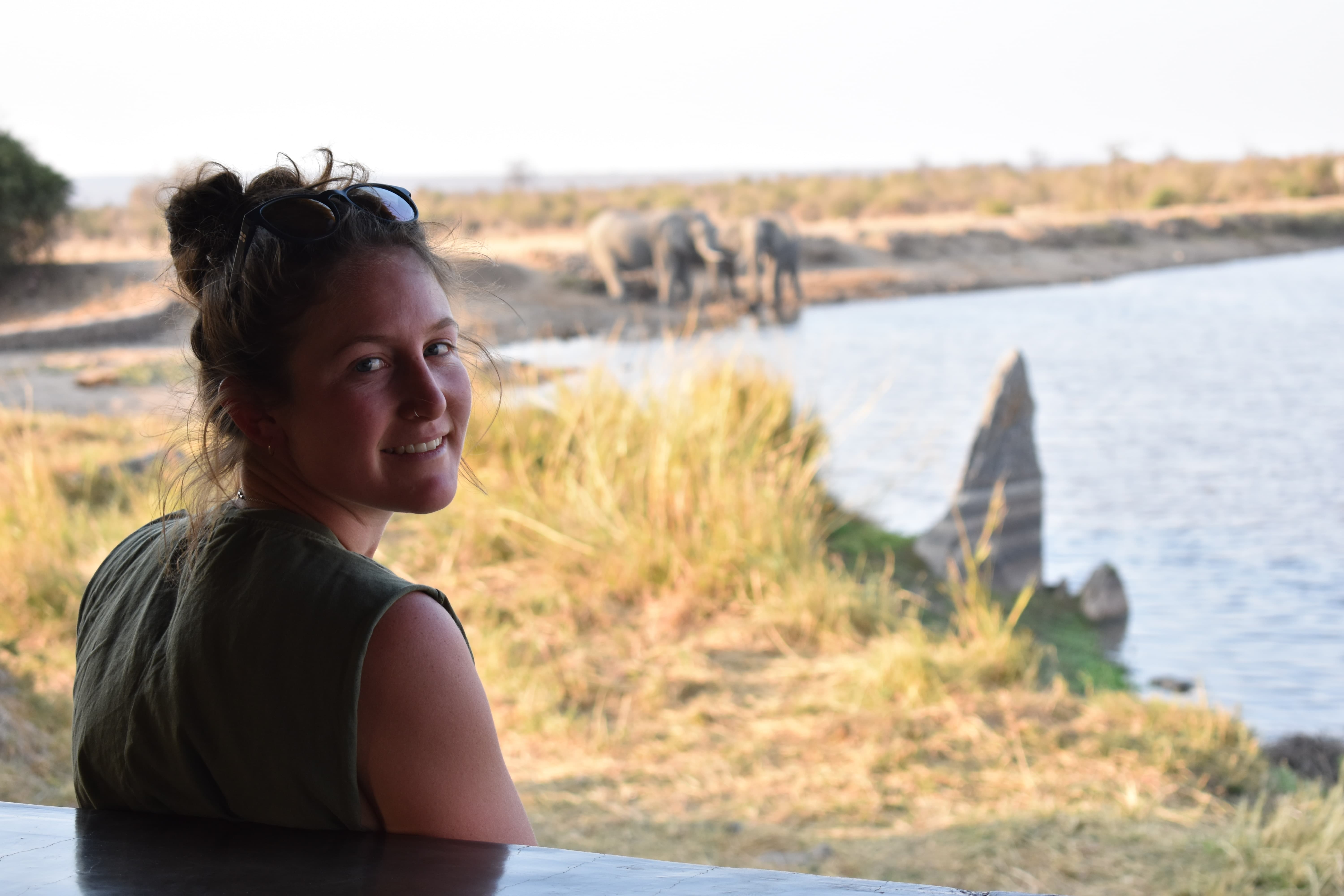 Woman looking over elephants in Hwange Zimbabwe