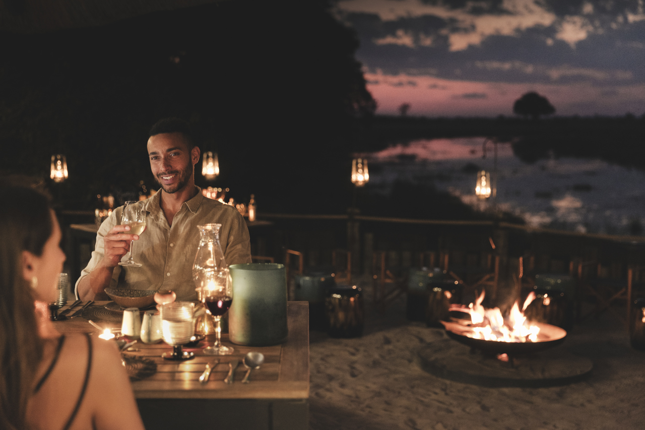 Couple having romantic fireside dinner on safari Wilderness