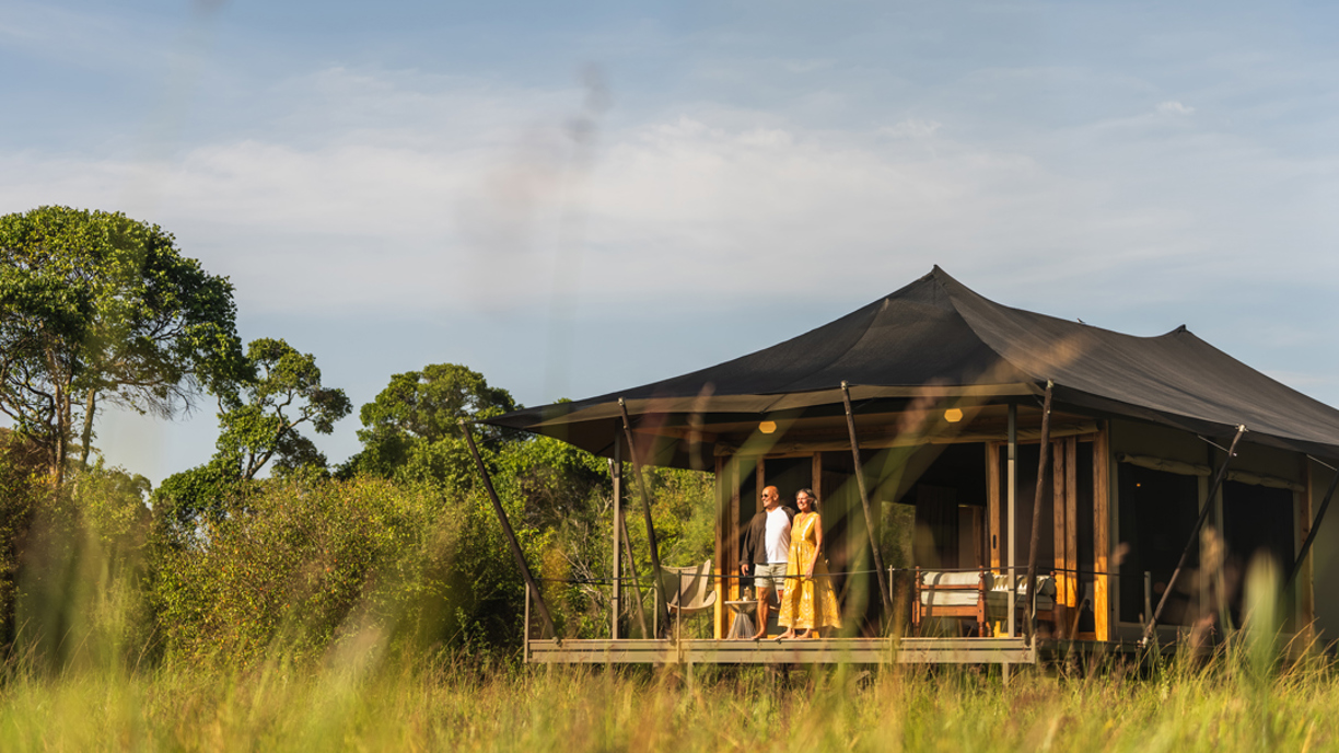 Guests enjoying the view of the marsh and wildlife from the deck of their Wilderness Mara tent in Kenya