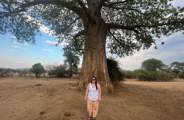 Woman posing in front of a baobab tree in lower Zambezi