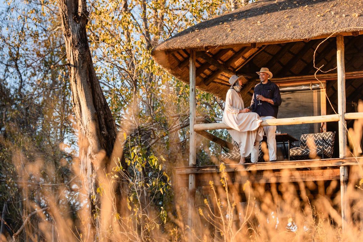 Guests enjoying some down time on the private deck of their tent at Wilderness Savuti