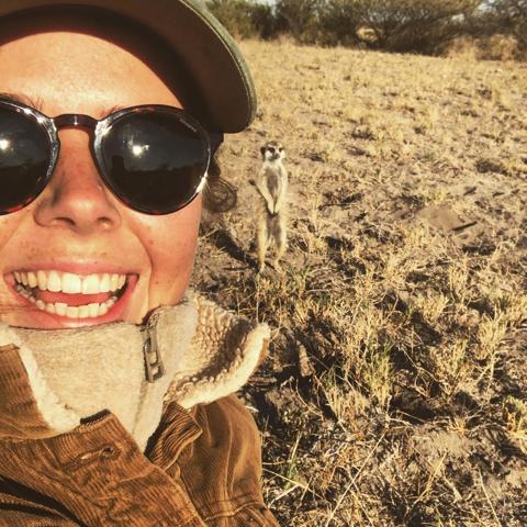 Picture of woman with a meerkat in the background