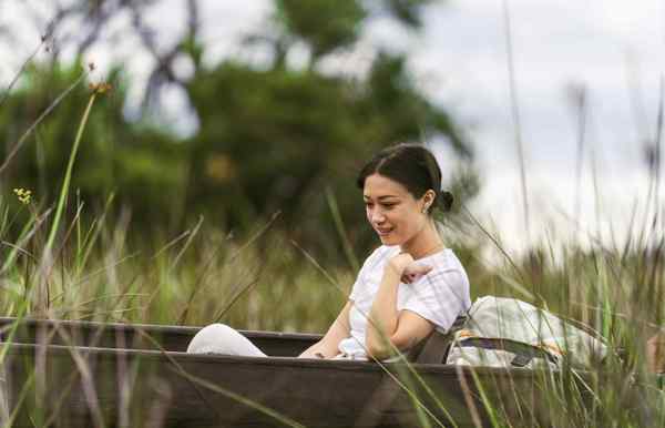 A woman floating along the calming waters of the Okavango Delta with Wilderness