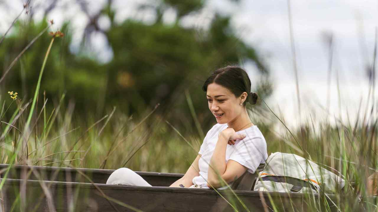A woman floating along the calming waters of the Okavango Delta with Wilderness