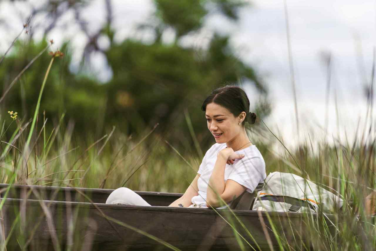 A woman floating along the calming waters of the Okavango Delta with Wilderness