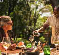 Guest enjoying al fresco dining at Wilderness Mara, Kenya