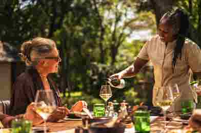 Guest enjoying al fresco dining at Wilderness Mara, Kenya