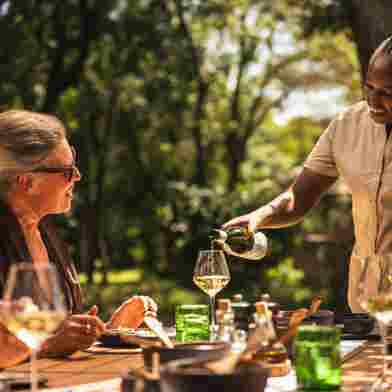 Guest enjoying al fresco dining at Wilderness Mara, Kenya