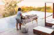 Guest enjoying a spa treatment poolside at Wilderness Qorokwe