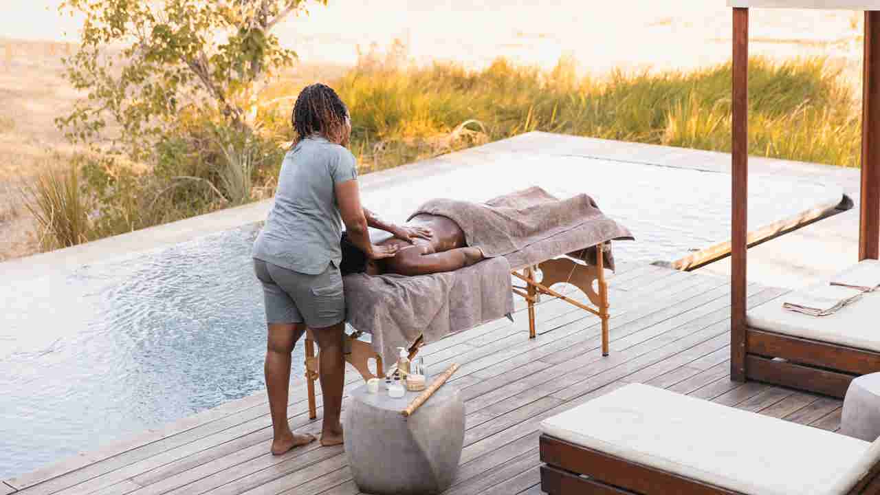 Guest enjoying a spa treatment poolside at Wilderness Qorokwe