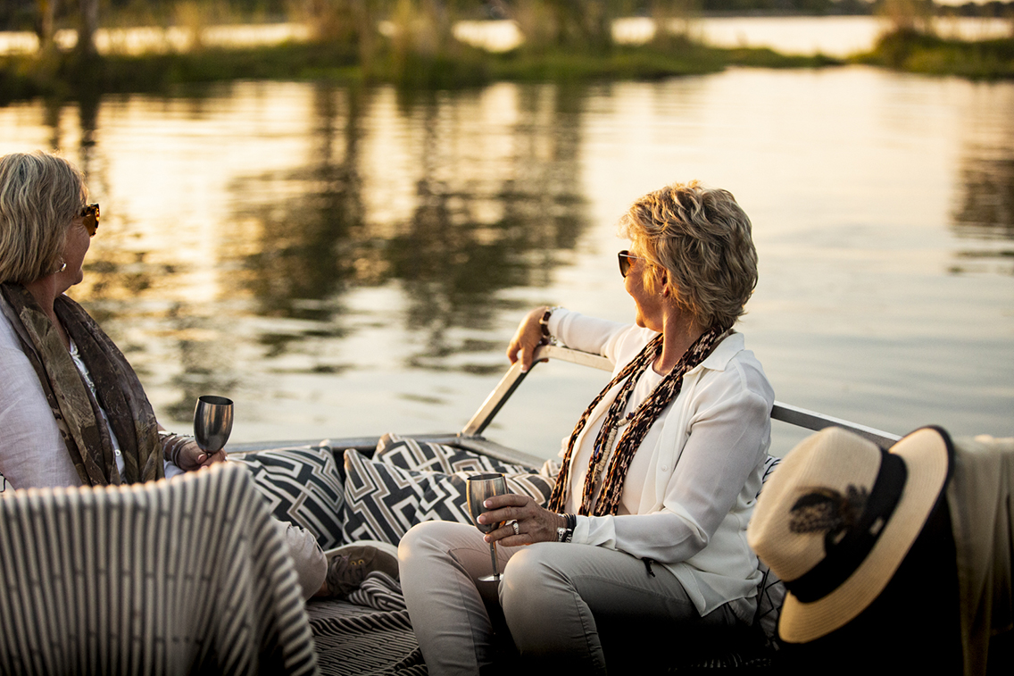 Two guests enjoying a boat cruise with sundowners in Wilderness Zambia Toka Leya