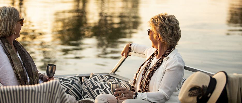 Two guests enjoying a boat cruise with sundowners in Wilderness Zambia Toka Leya