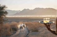 A couple exploring the Namib desert on quad bikes on their way to a sundowner