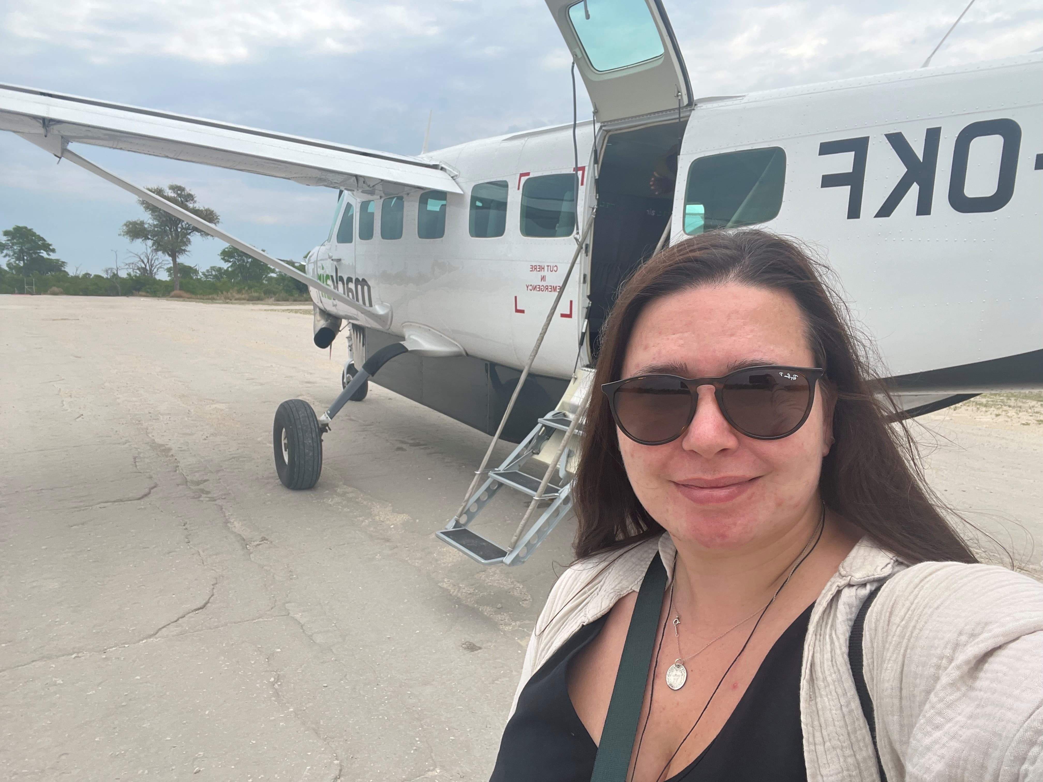 Woman posing in front of airplane