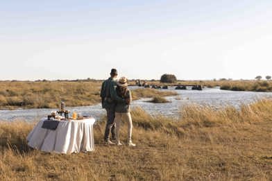 Couple at romantic sundowner Wilderness Botswana