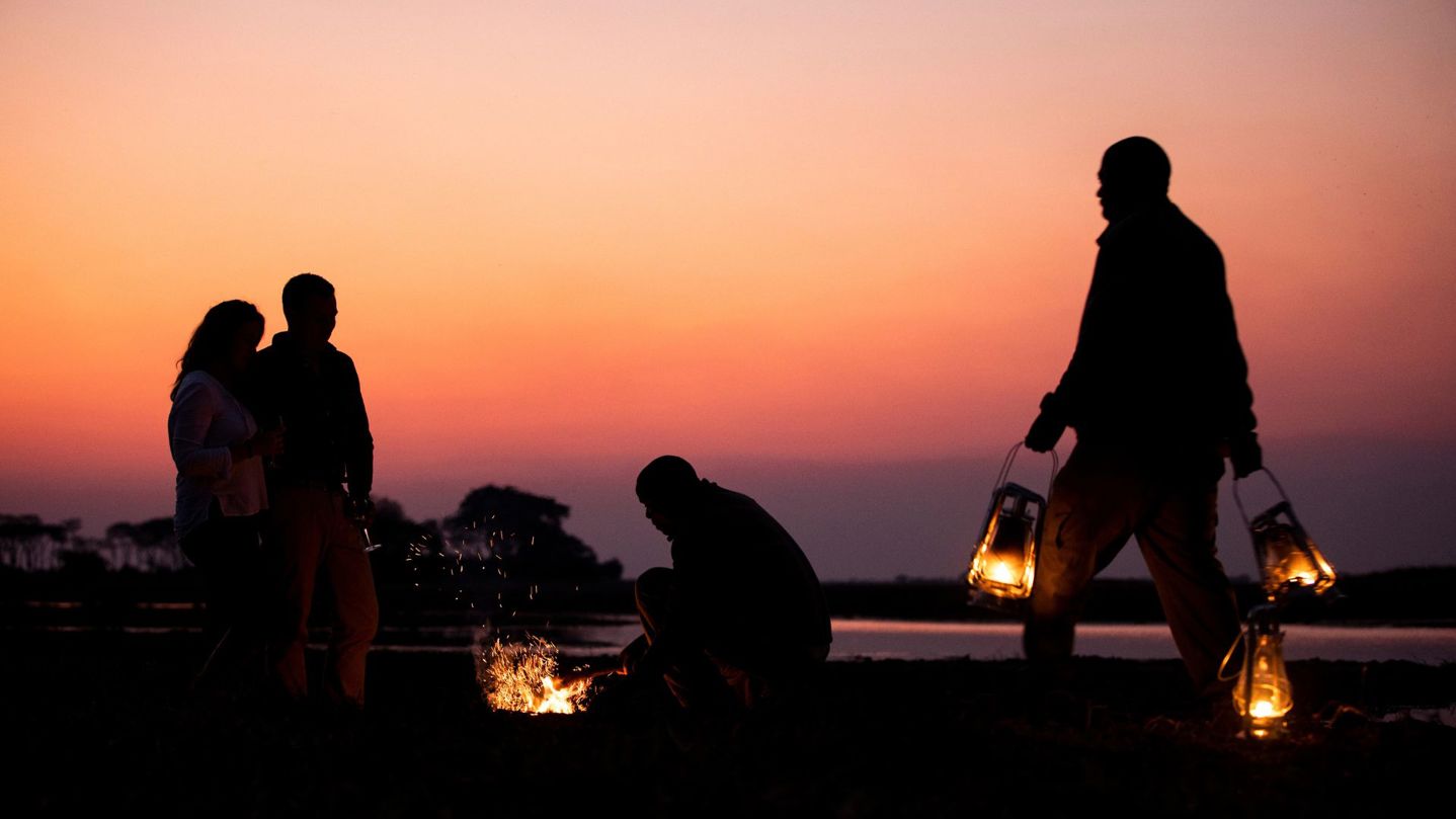 Sunset image of guests around campfire