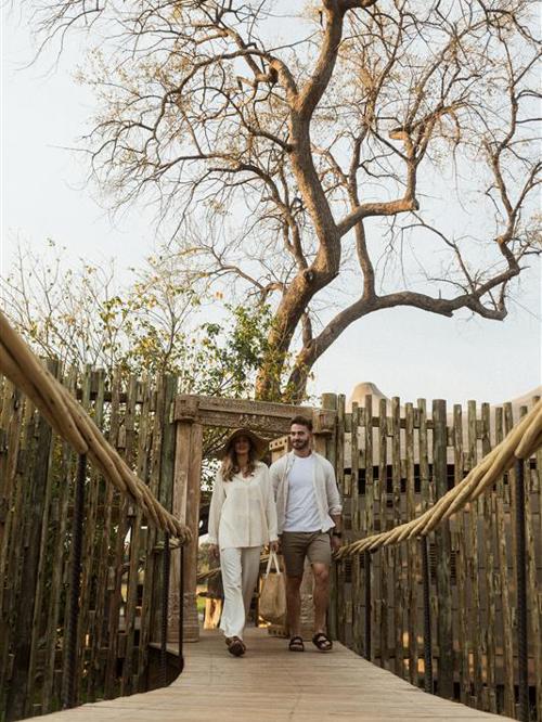 Couple walking on Wilderness Mombo walkway